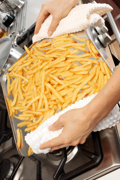 WOMAN IN KITCHEN COOKING CHIPS