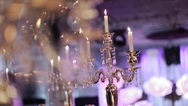 candles burning in tall glass candlestick, a restaurant, banquet, decoration, candles at the wedding table, decorative candles are lit on the festive table, close-up