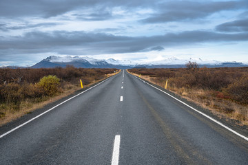 Fototapeta na wymiar Empty Stretch of a Road Leading to Snow Covered Mountains in Iceland in Autumn
