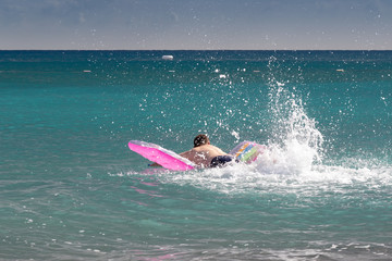 A man on a mattress in the water
