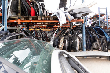 Auto parts market. On the ground are doors, bumpers and windshields.