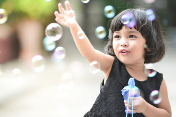 Asian little cute girl or kid blow,play air soap bubbles with smile. happiness,fun and childhood...
