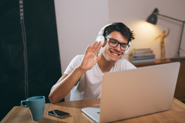 teenage boy chatting with his friends using laptop