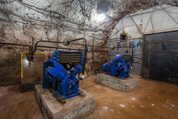 Underground gold iron ore mine shaft tunnel gallery passage with air compressors