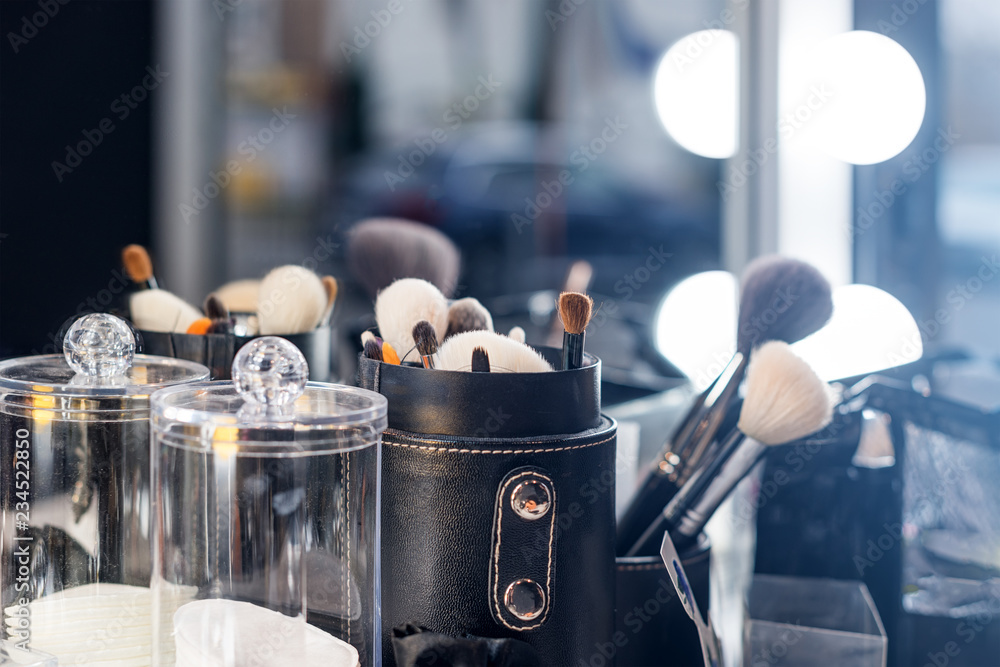 Canvas Prints Professional makeup brushes on make-up table with vanity lighting.