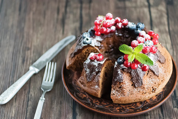 Homemade chocolate cake with chocolate icing, cream, mint  and fresh berries.