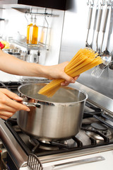 WOMAN IN KITCHEN COOKING SPAGHETTI