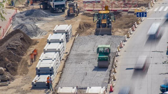 Green vibration roller compactor rolls on a stones at road construction and repairing timelapse