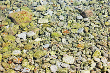 Pebble stones under clear water in the sea