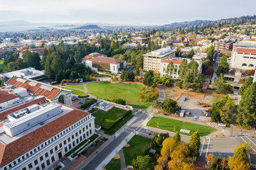Fototapeta na wymiar Aerial view of buildings in University of California, Berkeley campus on a sunny autumn day, view towards Richmond and the San Francisco bay shoreline in the background, California