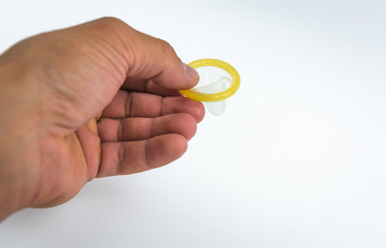 Close-up of a condom in his hand. Contraceptive protection against pregnancy, AIDS.