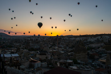 Beautiful sunset over Cappadocia, Goreme. Balloons flying against sky, aerial view. Most popular place in Turkey