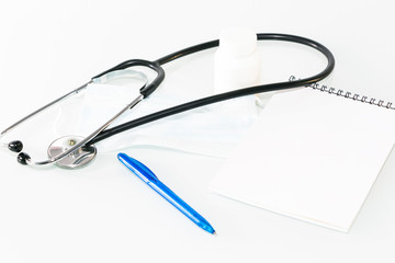 Stethoscope in the office of doctors.Top view of doctor's desk table, blank paper on clipboard with pen. Copy space.