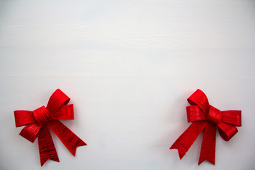 Red gift bow on white wooden table with copy space