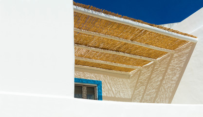 mediterranes weißes Haus mit Balkon und Sonnendach aus Schilfmatte © Wilm Ihlenfeld