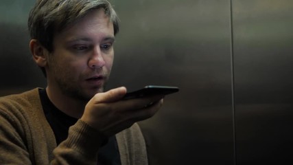 A businessman talking on the phone at the elevator student tourist man freelancer voice recognition ai speech audio message helper