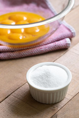 Fototapeta na wymiar Ramekin of sugar with a glass bowl of egg yolks in a baking scene