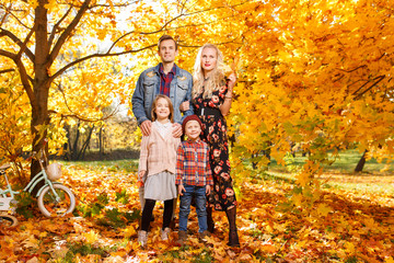 Photo of happy parents and children on walk in autumn park