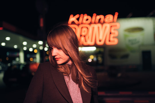 Young woman in coat standing near Kibinai drive inscription