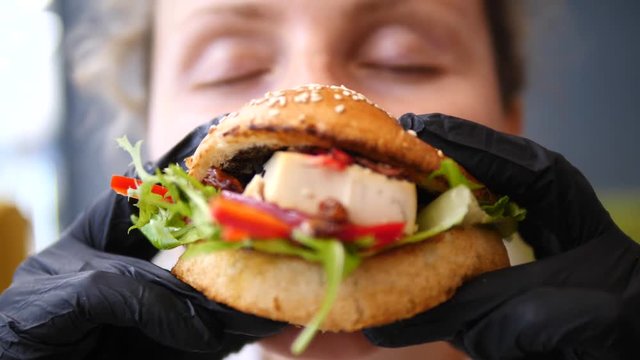 Woman Eating Vegan Burger. Closeup.