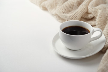 A Cup of fragrant black coffee and a textured wool blanket. Warm tone