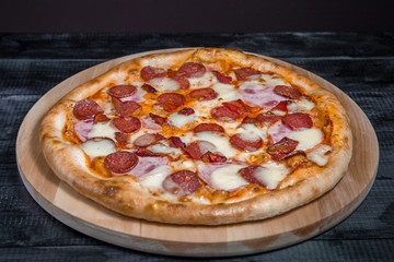 Hot Homemade Pepperoni Pizza with salami, cheese, sausage on dark background