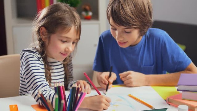 Two caucasian children drawing picture together