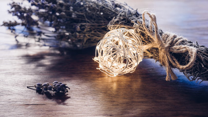 Winter aroma bouquet of dry lavender with christmas lights on a wooden table. Rustic style