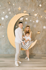 New year's portrait of young parents with a young son on a pendant . New year and Christmas concept