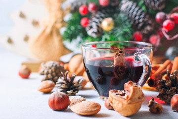 Christmas composition. Glass of red mulled wine on table with cinnamon sticks, Christmas decorations.