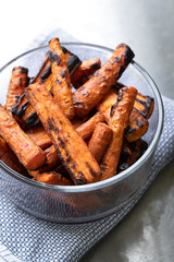 Roasted carrots in a glass bowl, on a blue towel