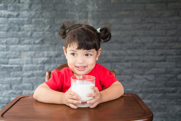 Asian little girl drinking a glass of milk at home, healthy concept