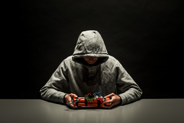 Terrorist is holding home made bomb with cables and remote controled detonator. Preparation for...