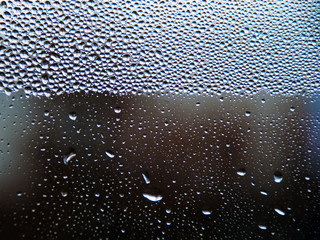 Drops of water on a cold glass.