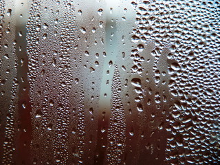 Drops of water on a cold glass.
