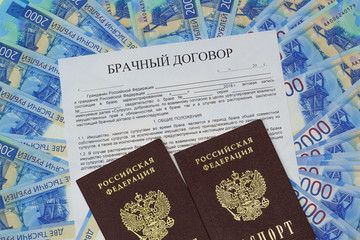 On the background of the new Russian paper money is a form of the marriage contract and two passports