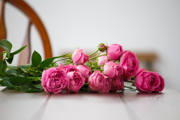Photo of pink peonies on white wooden table