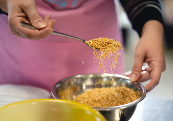 the chef in the kitchen sprinkles with spoons of spice