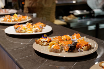 Salmon tapas on open kitchen counter, hard light