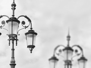 Fototapeta na wymiar Metal outdoor lanterns against the sky in black and white shot