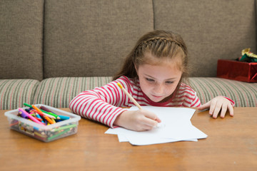 A cute little child American  girl doing homework at home. Kid enjoy learning at home. Education and learning concept