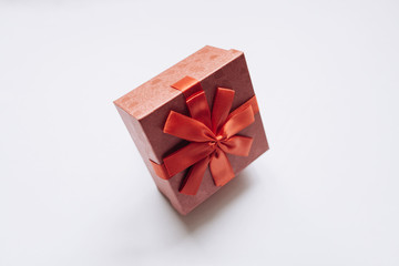 Red box with a bow with a gift on a white background.