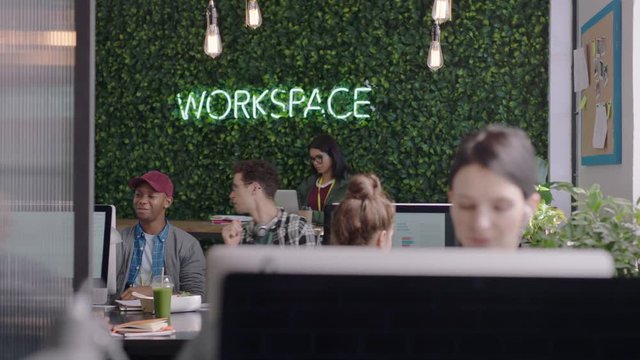 young group of business people working team leader woman training intern pointing at computer screen sharing ideas showing support colleagues collaborating in diverse modern office