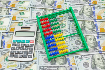 Image of abacus and calculator on money background