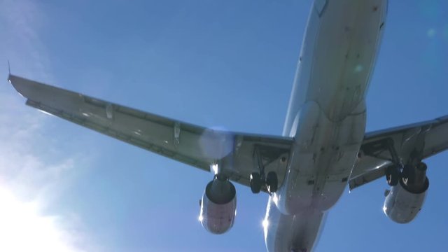 Slow motion shot of undercarriage of commercial jet coming into land. Airbus 319-112. Toronto, Canada. No logos visible.