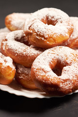 doughnuts sprinkled with powdered sugar on a white plate, selective focus