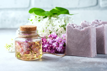 Handmade soap, Glass jar with fragrant oil and lilac flowers for spa and aromatherapy.