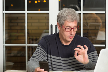 man gesticulating at the computer, there seems to be an interloutor on the other side