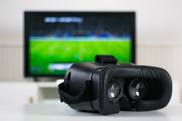 VR headset in front of blurred TV background - VR Goggles - Gaming