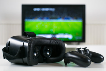 VR headset in front of blurred TV background - VR Goggles - Gaming